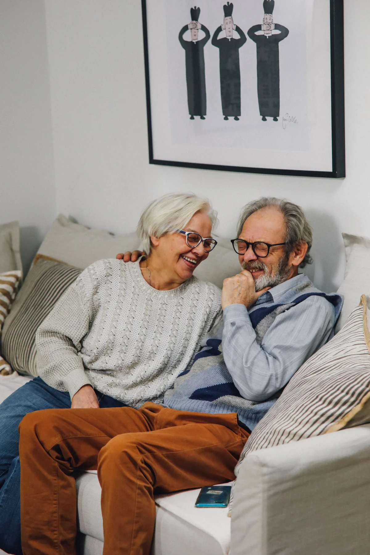 An older couple sitting comfortably together on their sofa